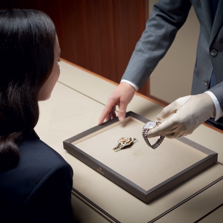 A lady overlooking a Rolex watch being presented to her