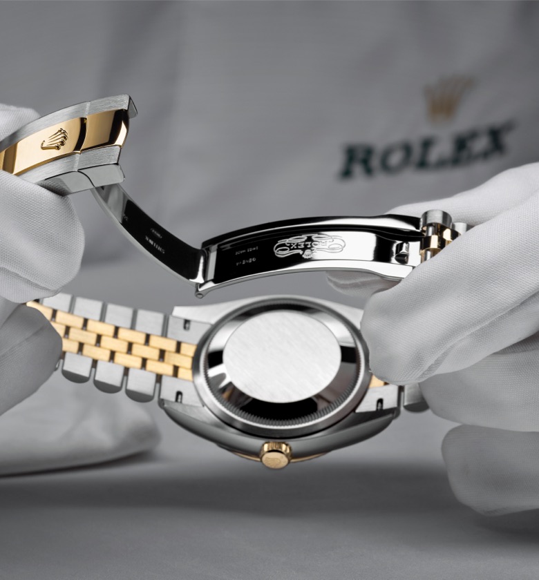 Hands holding a Rolex watch being serviced